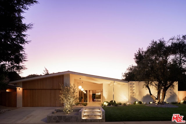 view of front of property with a garage and a yard