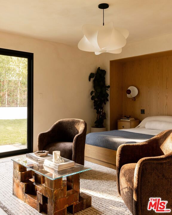 bedroom with access to exterior and wooden walls