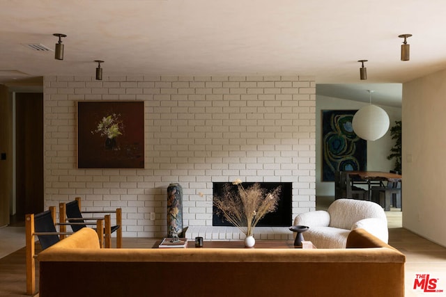 living room with hardwood / wood-style floors and a brick fireplace