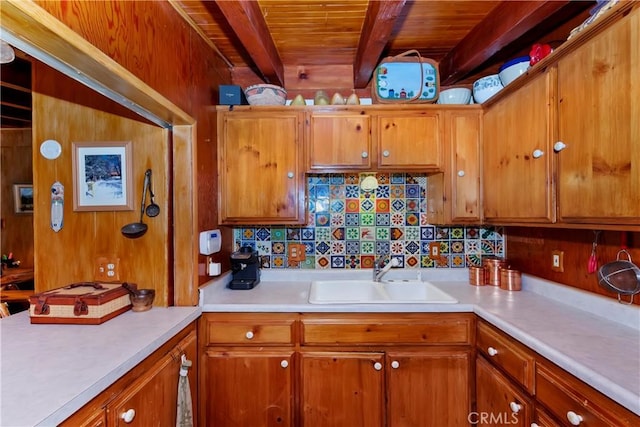 kitchen featuring beam ceiling, backsplash, sink, and wooden ceiling