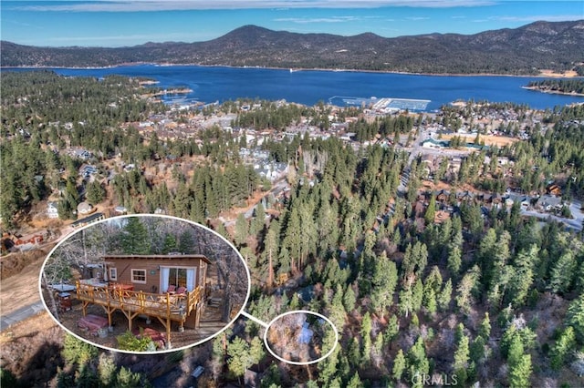 birds eye view of property with a water and mountain view