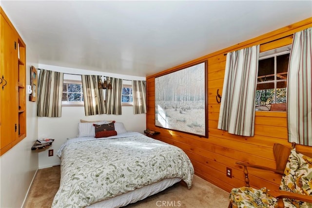 bedroom featuring wood walls and light colored carpet