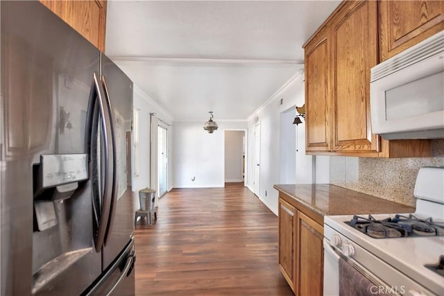 kitchen with white appliances, tasteful backsplash, crown molding, and dark wood-type flooring