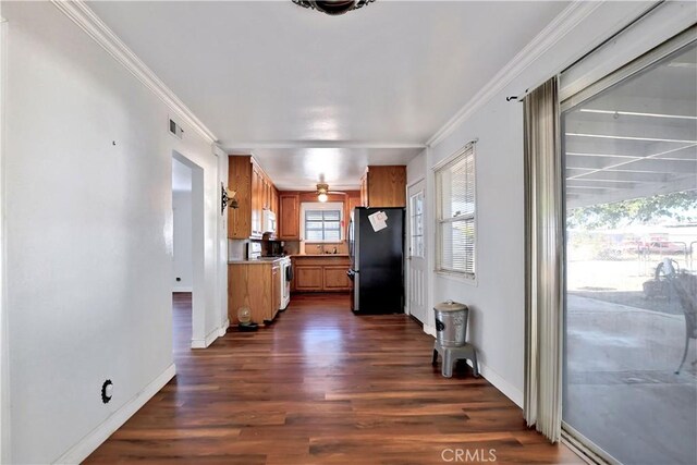 kitchen featuring white range with electric stovetop, stainless steel fridge, crown molding, and dark hardwood / wood-style floors