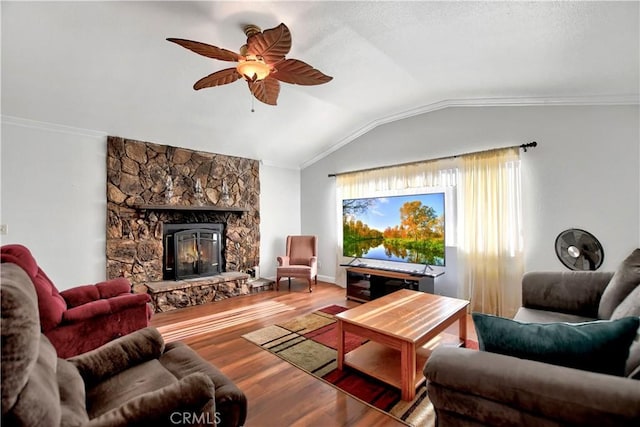 living room with ceiling fan, lofted ceiling, hardwood / wood-style flooring, a fireplace, and ornamental molding