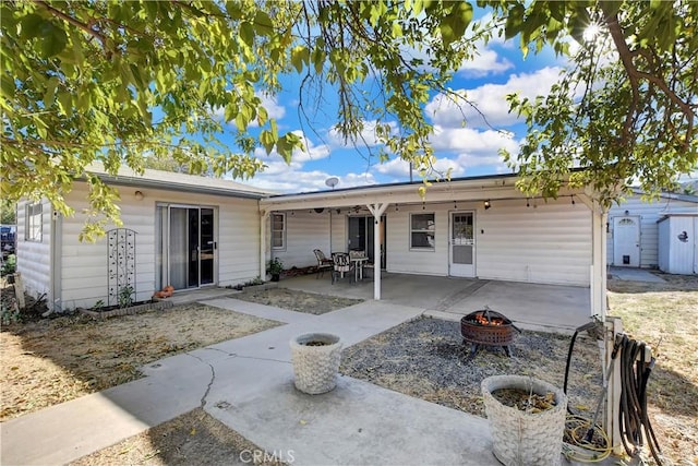 rear view of house with a patio area and an outdoor fire pit