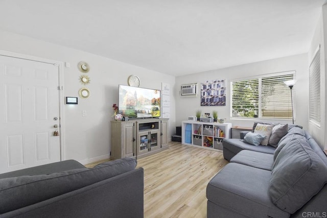 living room featuring a wall mounted AC and light hardwood / wood-style floors