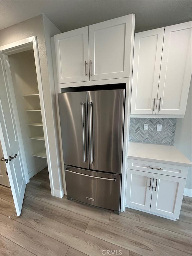 kitchen featuring decorative backsplash, white cabinets, and high end fridge