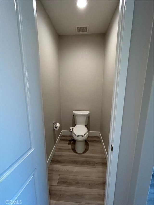 bathroom with toilet and hardwood / wood-style floors