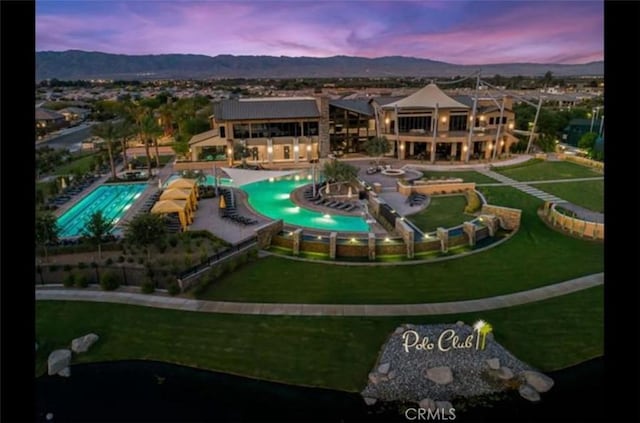 pool at dusk featuring a mountain view