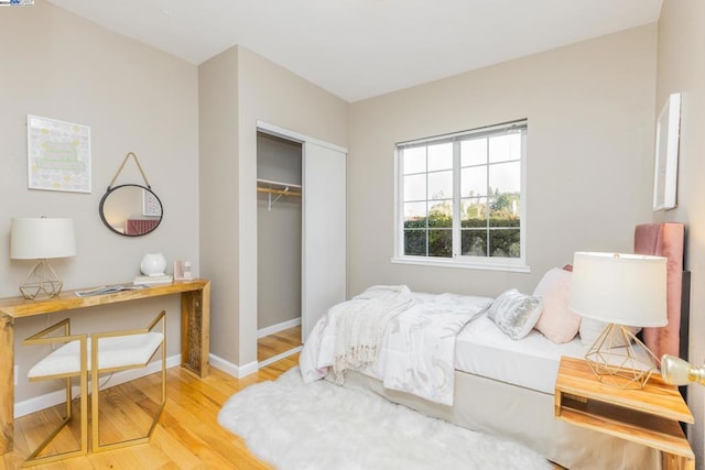 bedroom with light hardwood / wood-style flooring and a closet