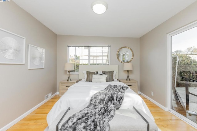 bedroom featuring access to exterior and hardwood / wood-style floors