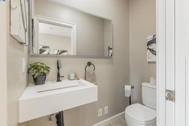 bathroom featuring wood-type flooring and toilet