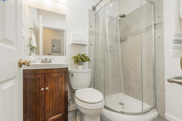 bathroom featuring vanity, electric panel, toilet, and a shower with door