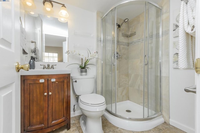 bathroom featuring tile patterned flooring, vanity, toilet, and an enclosed shower