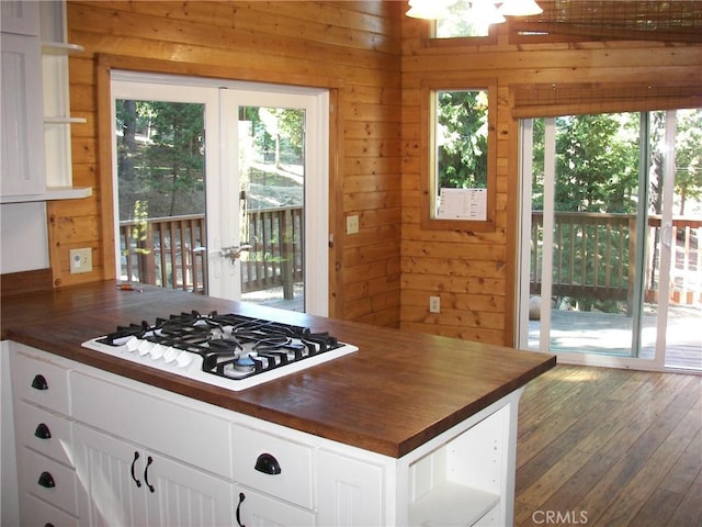 kitchen featuring wooden walls, wooden counters, a healthy amount of sunlight, and stainless steel gas cooktop