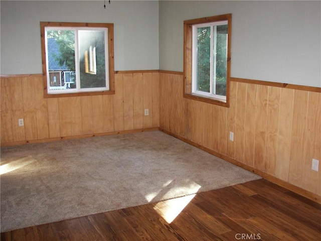 unfurnished room with dark hardwood / wood-style flooring and wooden walls