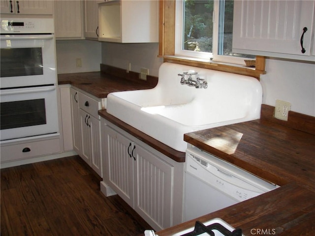 kitchen featuring dark hardwood / wood-style flooring, white appliances, sink, white cabinetry, and butcher block counters