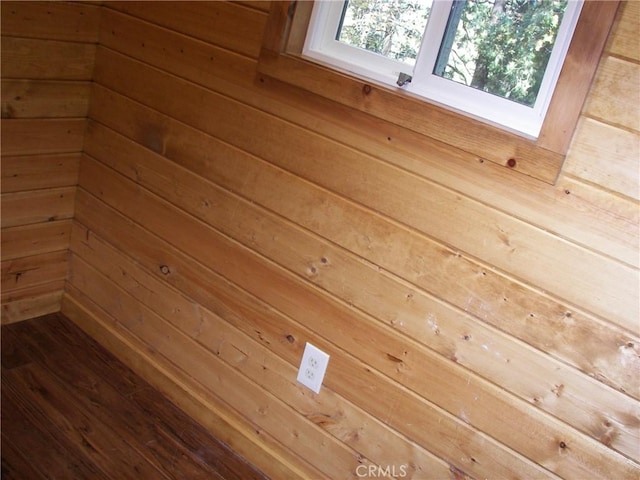 room details with wooden walls and hardwood / wood-style floors