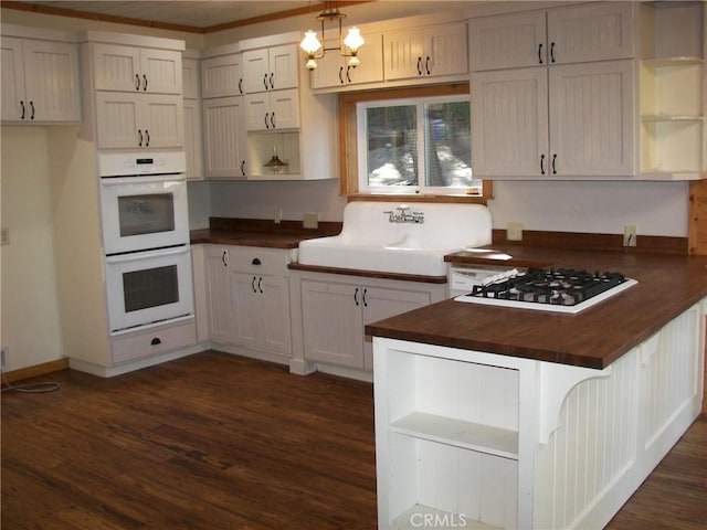 kitchen featuring dark hardwood / wood-style flooring, white appliances, sink, white cabinets, and butcher block countertops