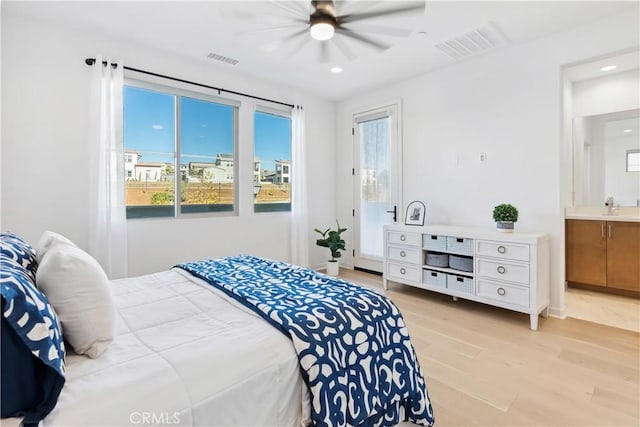 bedroom featuring connected bathroom, multiple windows, ceiling fan, and light wood-type flooring