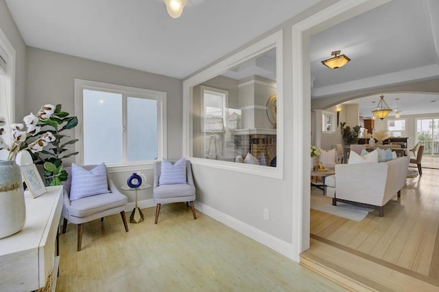 living area with crown molding and hardwood / wood-style flooring