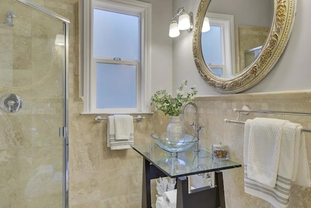 bathroom featuring plenty of natural light, tile walls, walk in shower, and sink