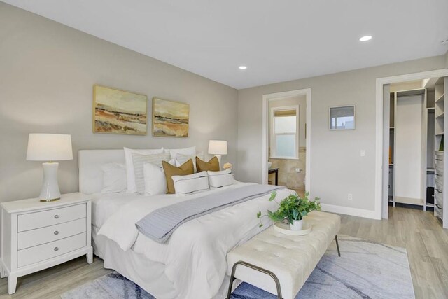 bedroom with ensuite bathroom and light wood-type flooring