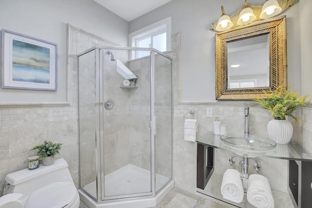 bathroom with toilet, a shower with door, and sink