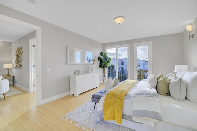 bedroom with access to exterior and light hardwood / wood-style flooring