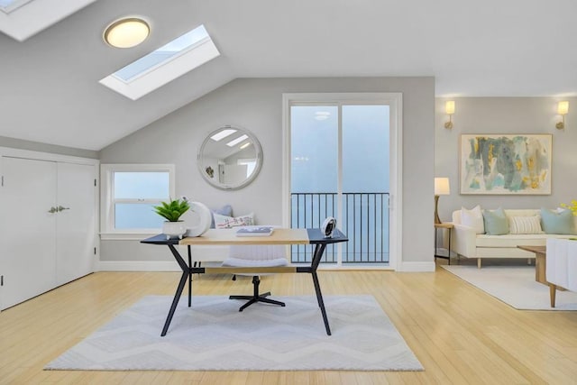 office featuring lofted ceiling with skylight and hardwood / wood-style floors