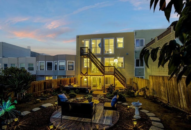 back house at dusk featuring a patio