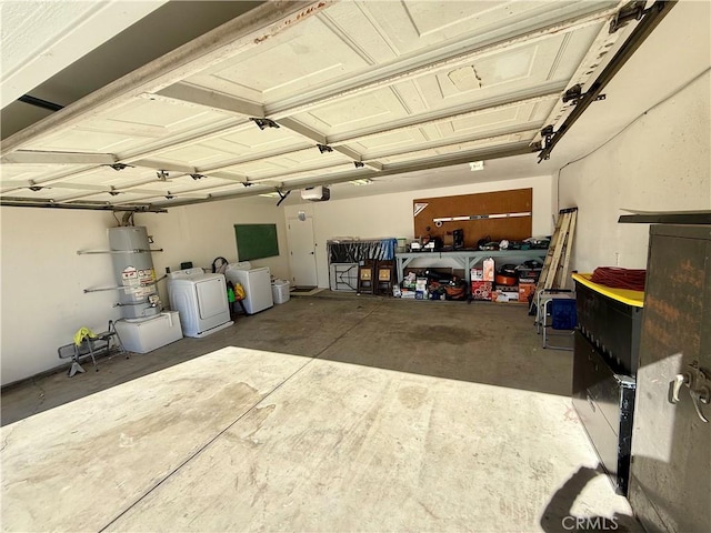 garage featuring washing machine and dryer, strapped water heater, and a garage door opener