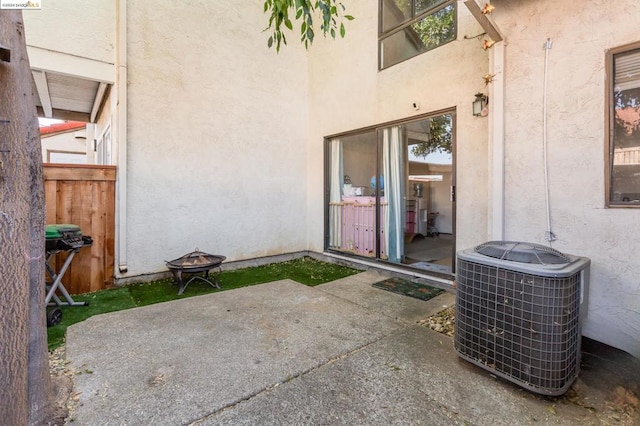 view of patio with an outdoor fire pit and central AC