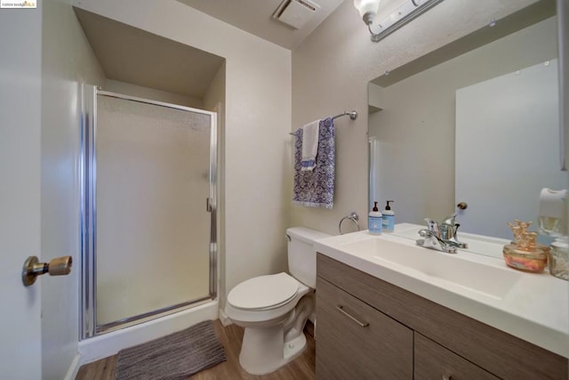 bathroom featuring walk in shower, toilet, vanity, and hardwood / wood-style flooring