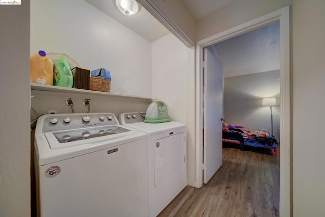 clothes washing area featuring light wood-type flooring and separate washer and dryer