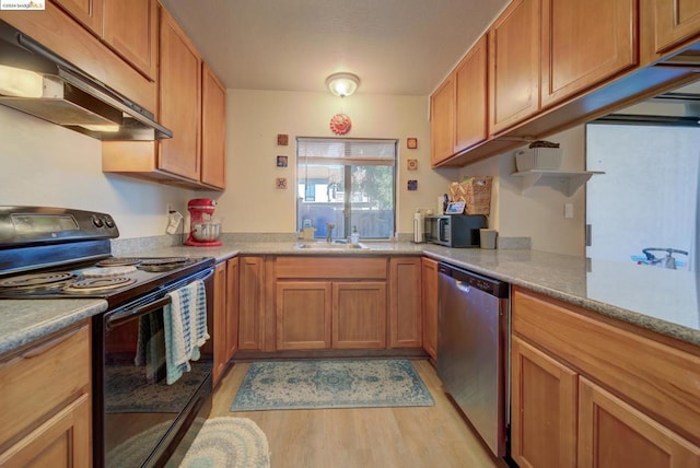 kitchen featuring sink, light stone countertops, stainless steel appliances, and light hardwood / wood-style flooring