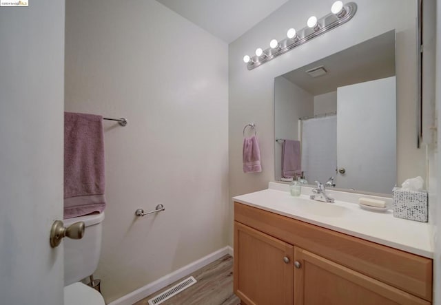 bathroom with a shower with curtain, toilet, vanity, and hardwood / wood-style flooring