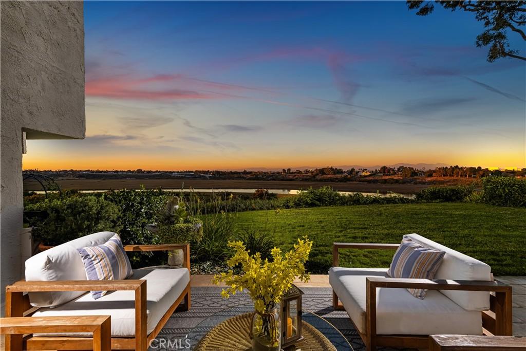 patio terrace at dusk featuring a yard