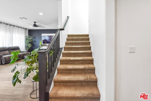 staircase featuring hardwood / wood-style flooring and ceiling fan