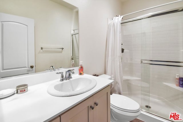 bathroom with a shower with shower curtain, vanity, and toilet