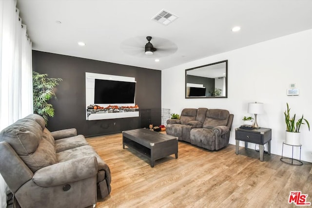 living room featuring ceiling fan and light hardwood / wood-style floors