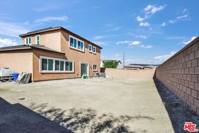 rear view of property with central AC