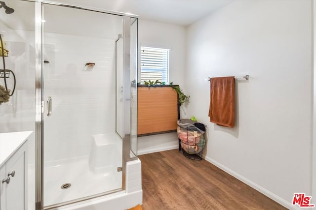 bathroom with hardwood / wood-style floors, vanity, and an enclosed shower