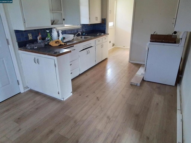 kitchen with white cabinets, sink, backsplash, and washer / clothes dryer