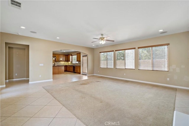 unfurnished living room with arched walkways, visible vents, recessed lighting, and light tile patterned flooring