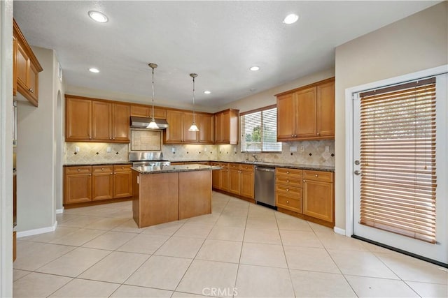 kitchen featuring under cabinet range hood, a center island, dishwasher, brown cabinetry, and decorative light fixtures