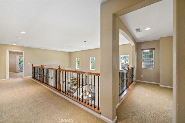 corridor with light carpet, recessed lighting, visible vents, and baseboards