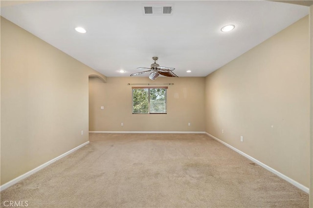 spare room featuring light colored carpet, visible vents, and baseboards