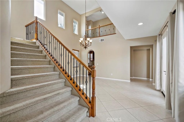 stairs featuring a healthy amount of sunlight, tile patterned flooring, baseboards, and arched walkways